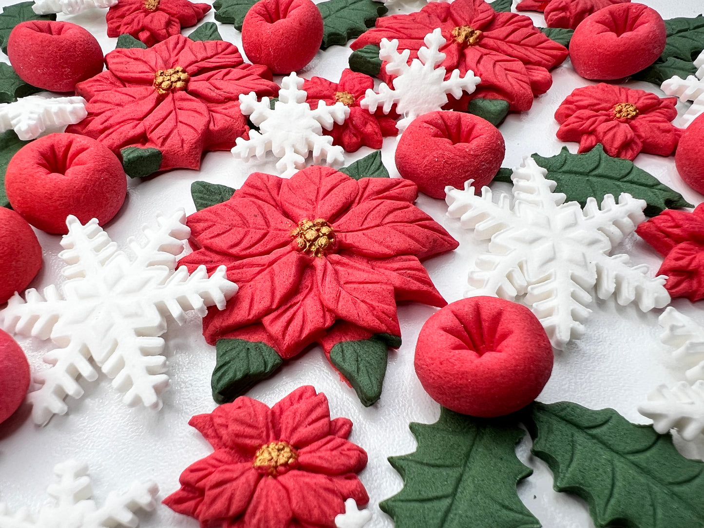 Close-up of edible fondant snowflakes and holly leaves