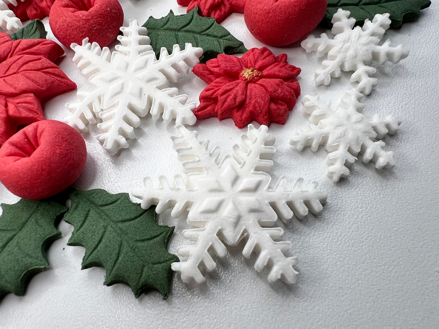 Decorative Christmas elements including snowflakes, holly leaves, and poinsettias on a light gray background.