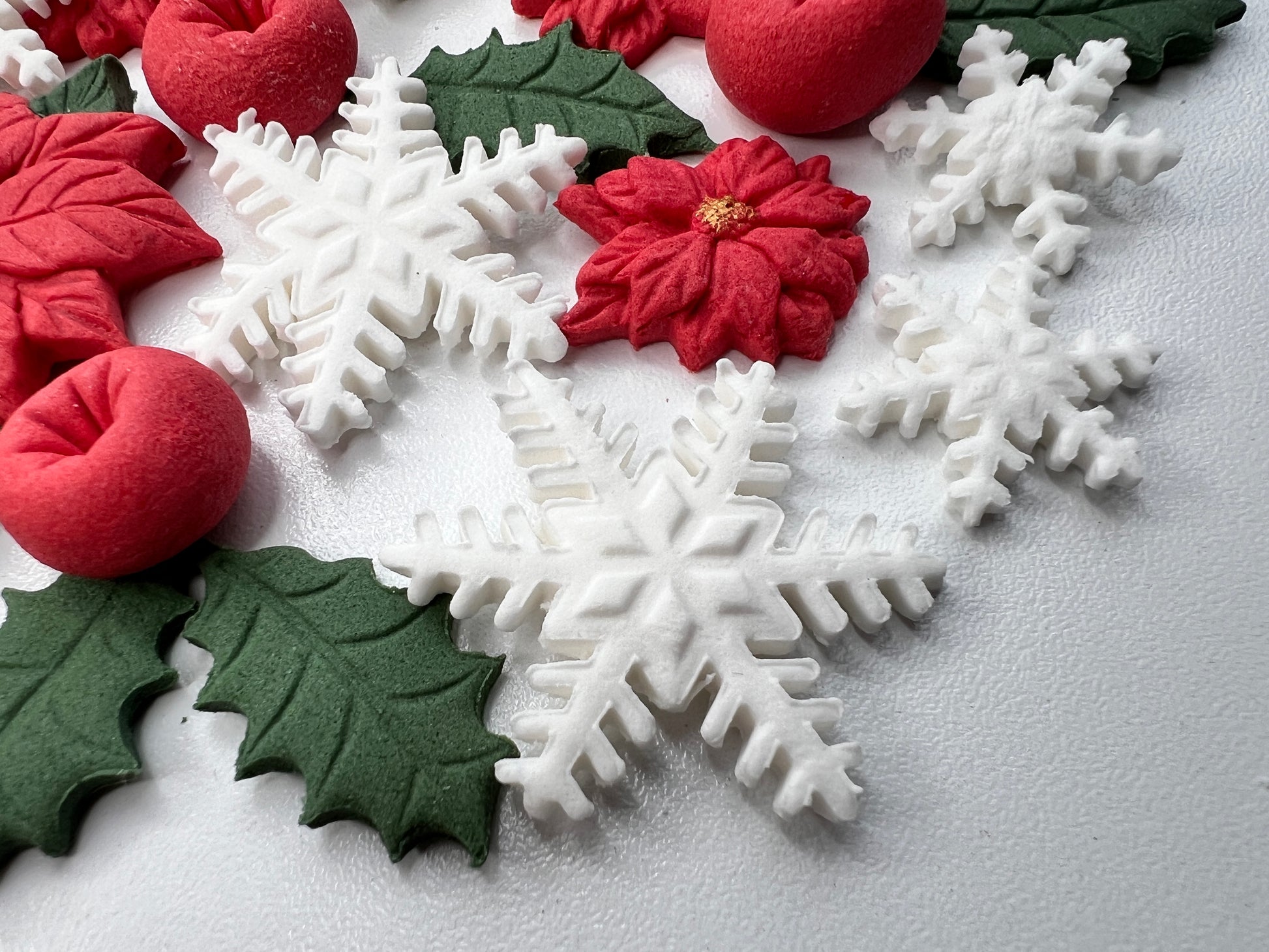 Decorative Christmas elements including snowflakes, holly leaves, and poinsettias on a light gray background.