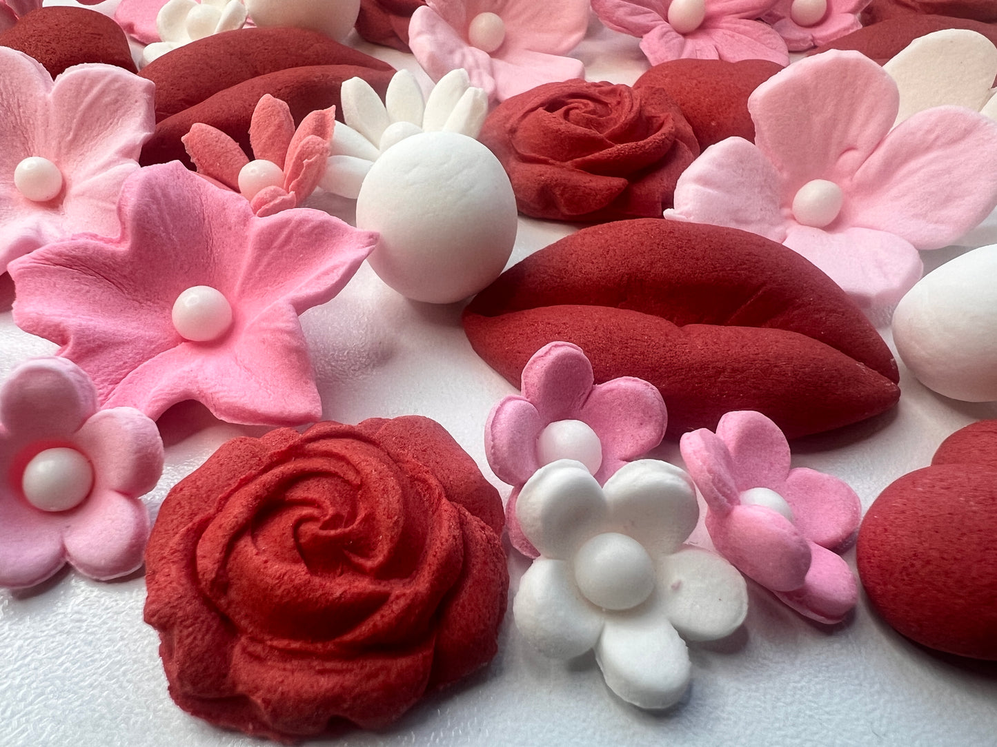 Close-up of red roses and lips made of fondant  and pink and white floral arrangement. 