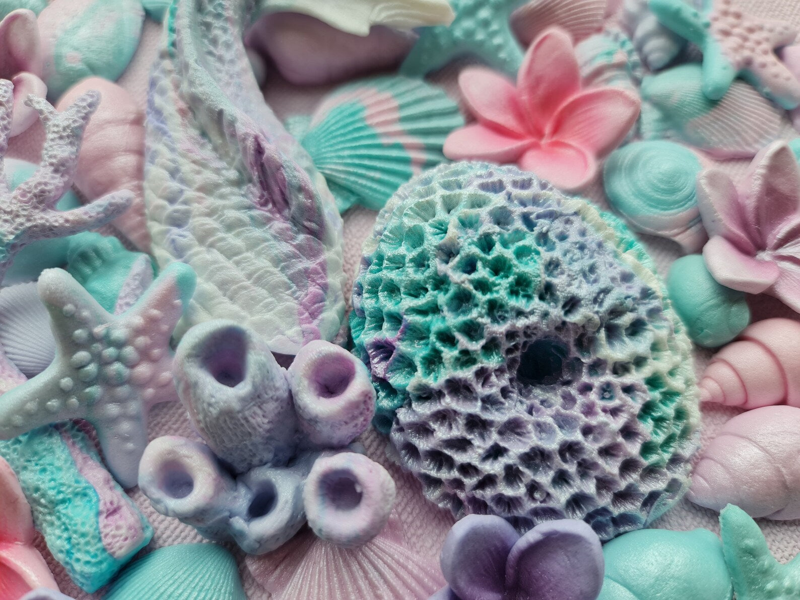 Colorful sea-themed fonadant  decorations including starfish, shells, and coral in pastel shades.