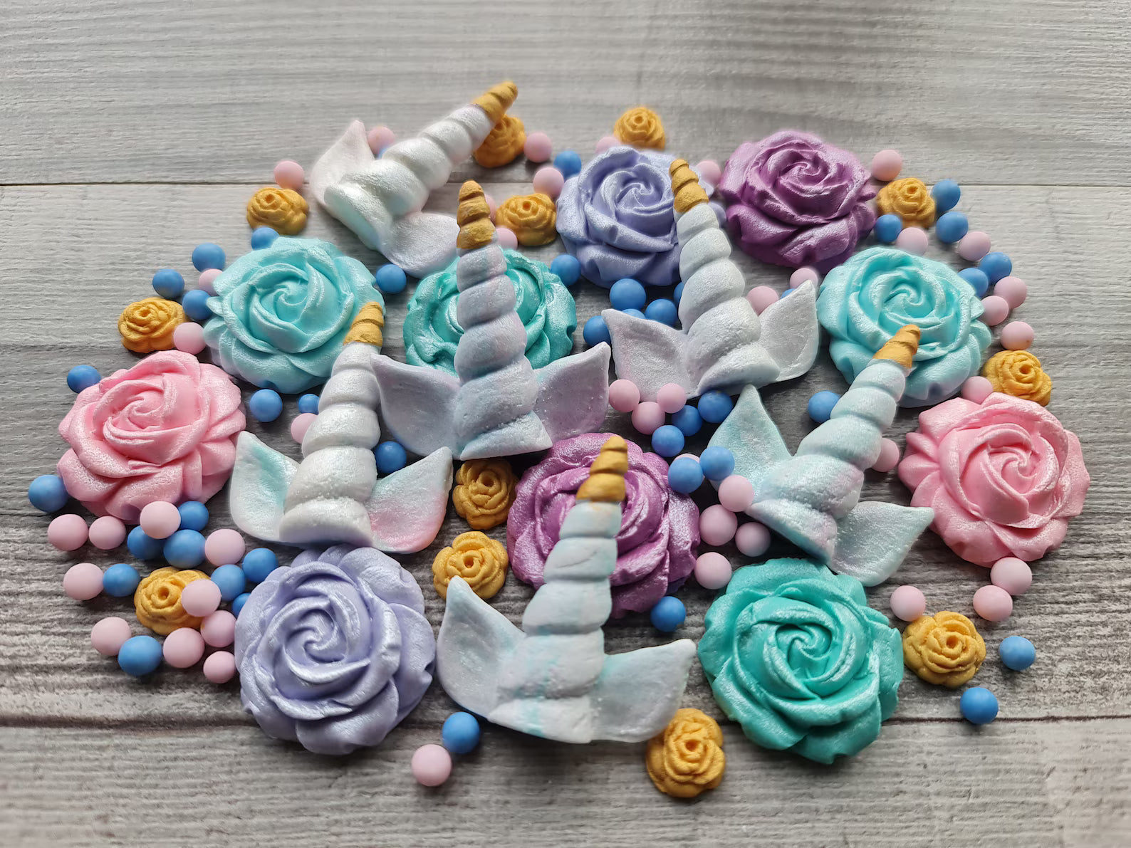 Handmade edible unicorn cake decorations with pastel roses and unicorn horns