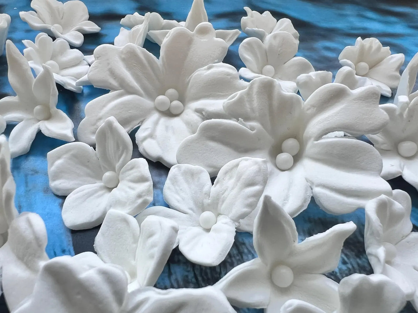 Detailed white fondant flower cake decorations with smooth petals