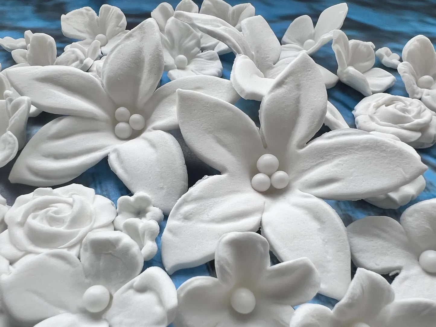 White edible sugar  flowers on a blue surface