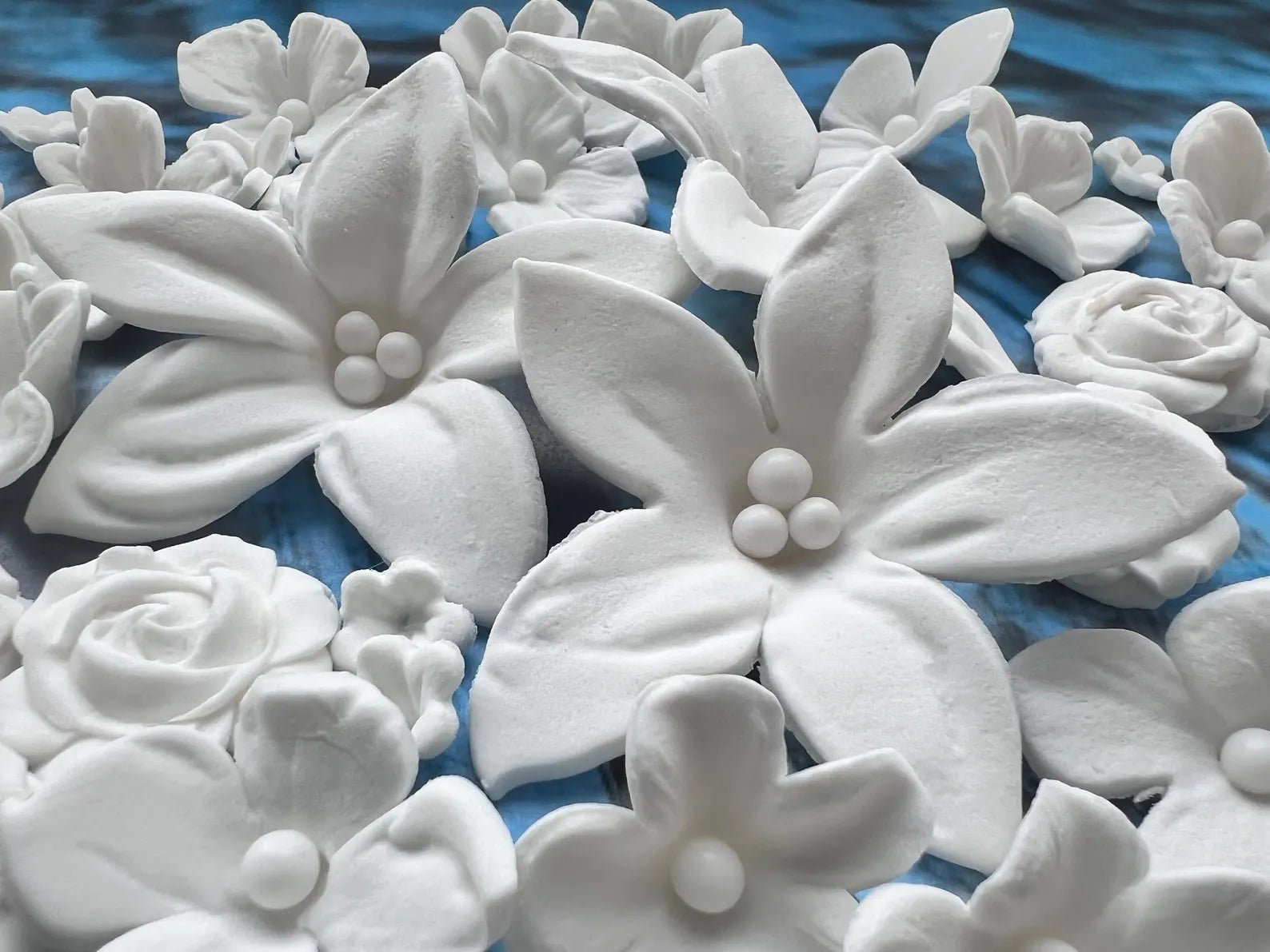 White edible sugar  flowers on a blue surface