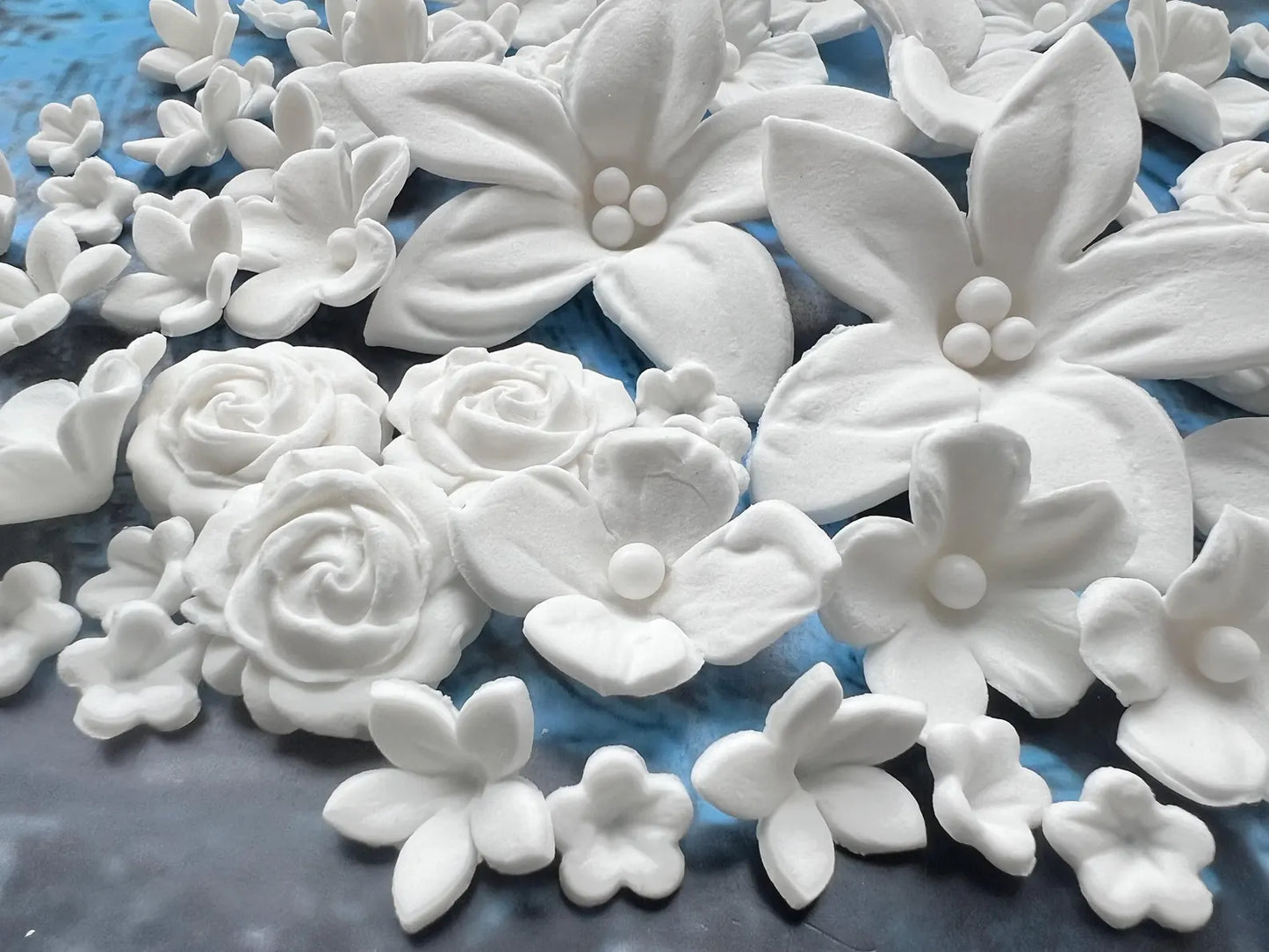 White sugar flowers on a blue surface
