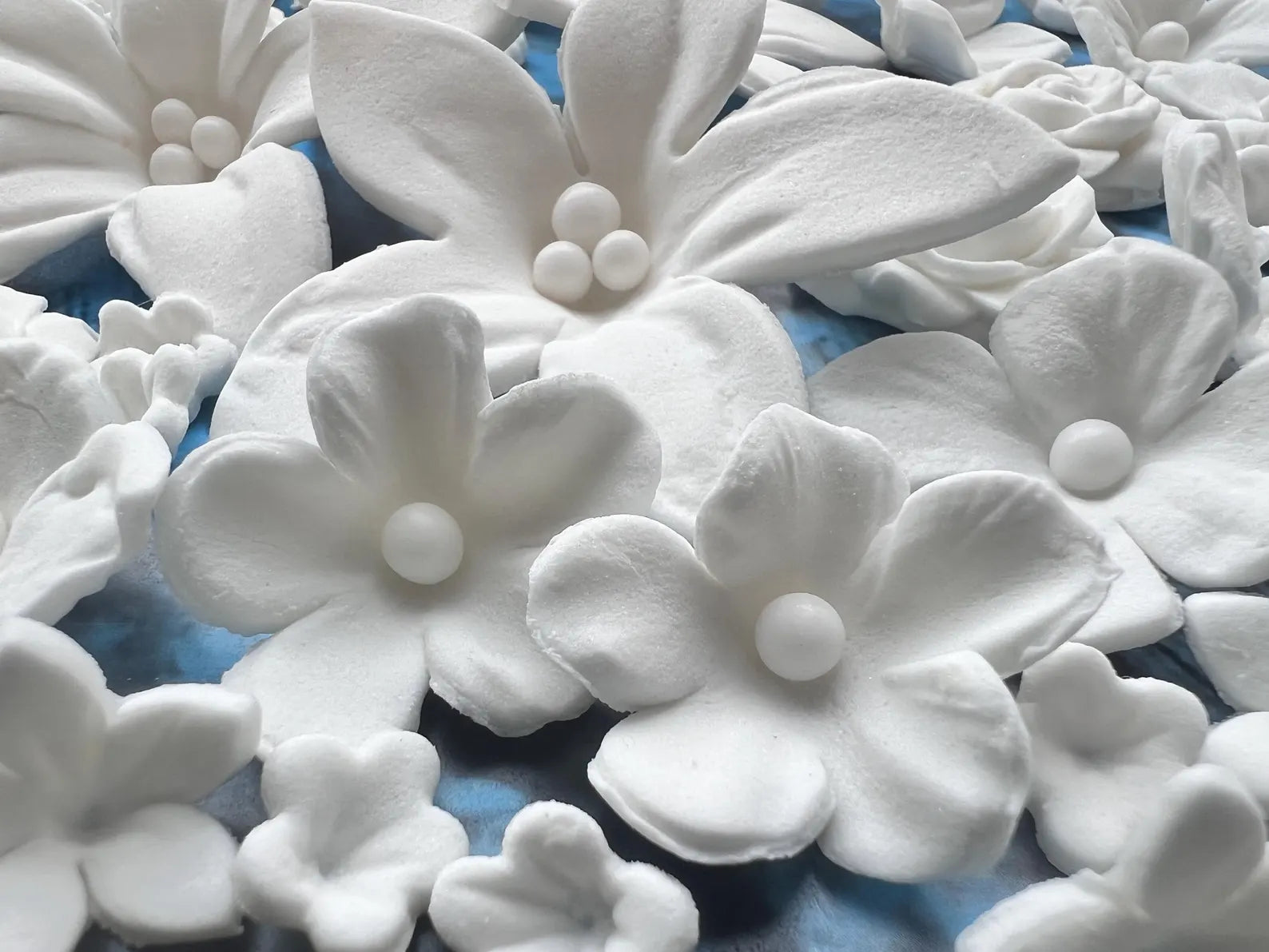 White floral sugar decorations on a blue background