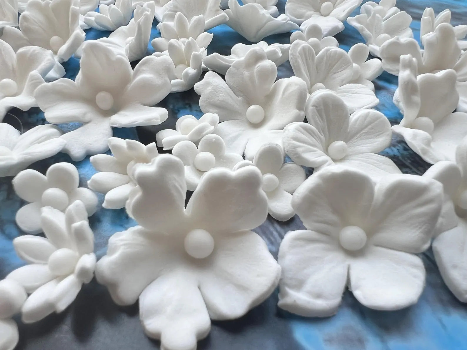 Assorted white fondant flower cake toppers close-up view