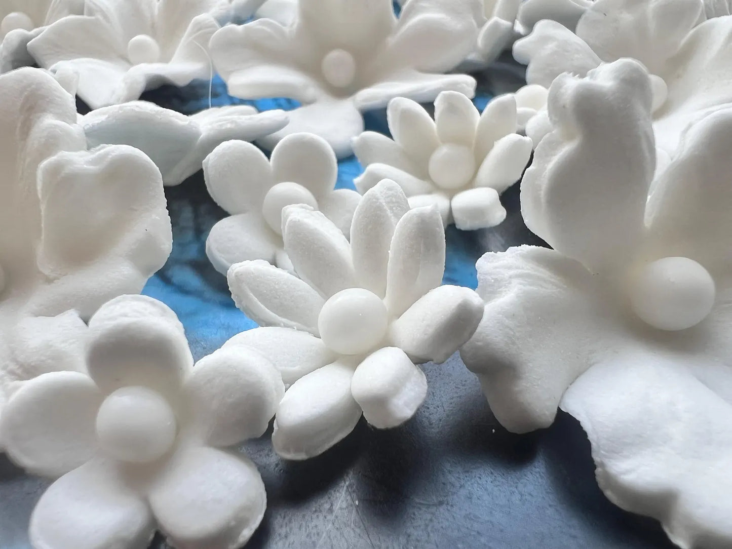 Detailed white fondant flower decorations for cake design