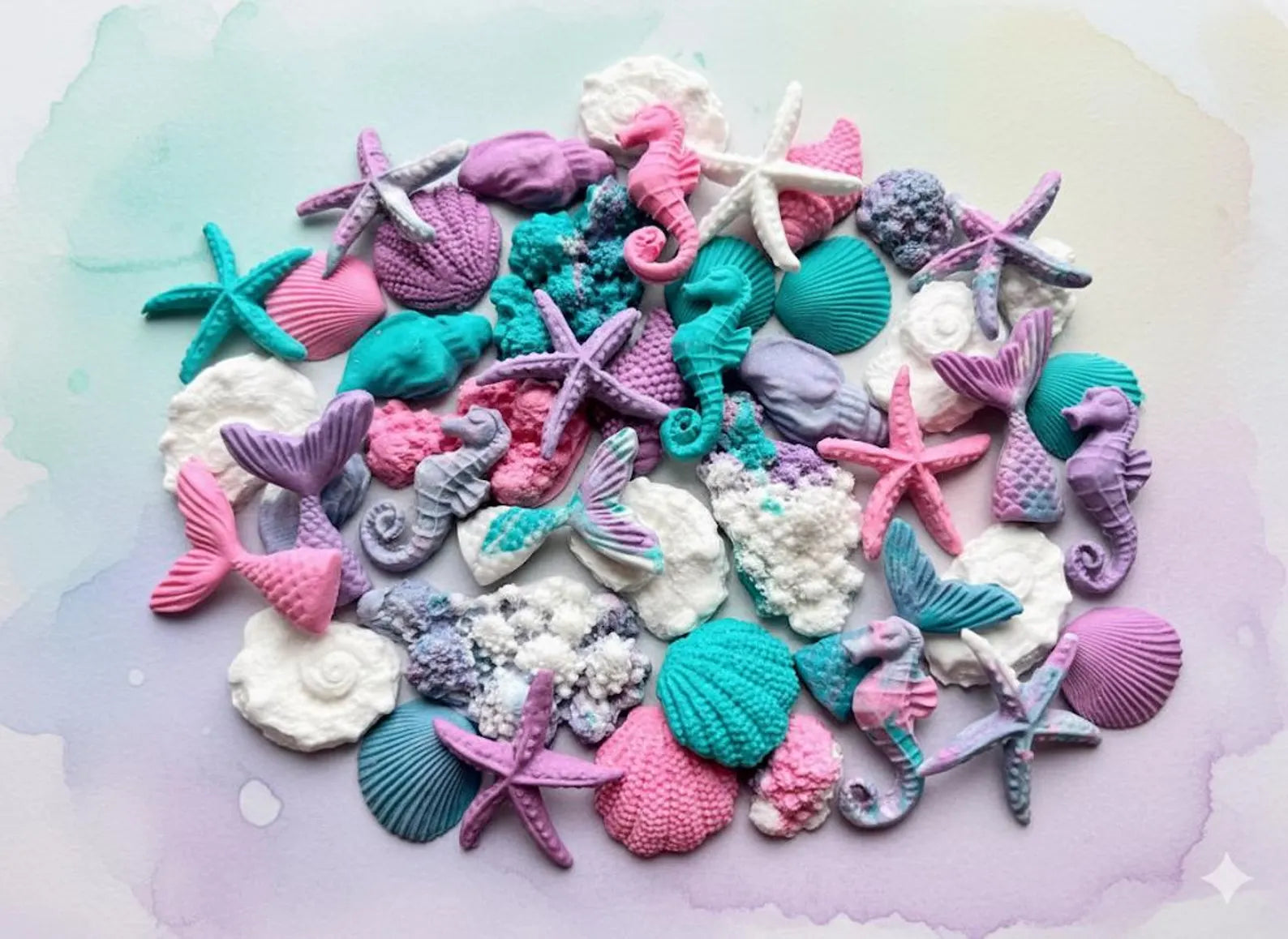 Colorful sea-themed sugar  decorations including seashells, starfish, and mermaid tails on a pastel background.