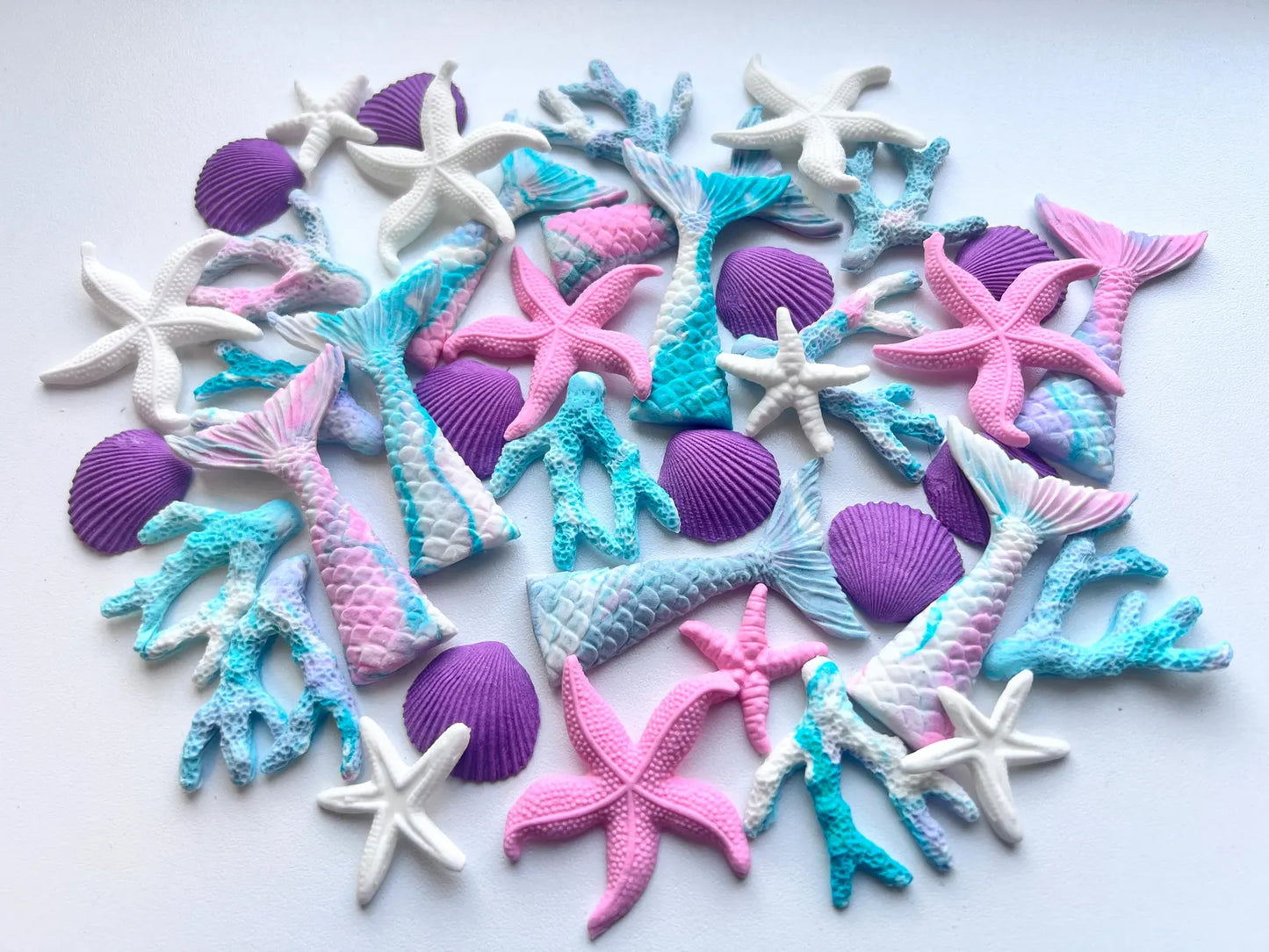 Colorful sugar starfish, mermaid fins  and shell decorations on a white background