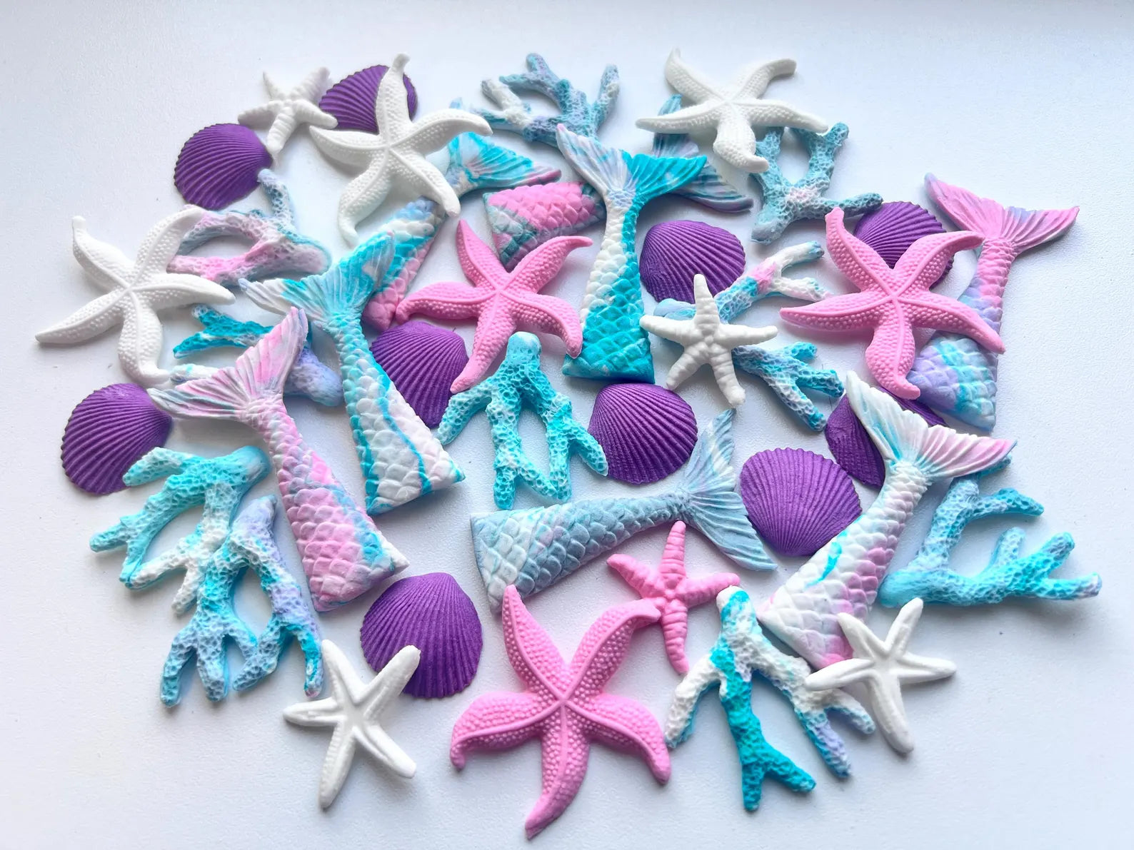 Colorful sugar starfish, mermaid fins  and shell decorations on a white background