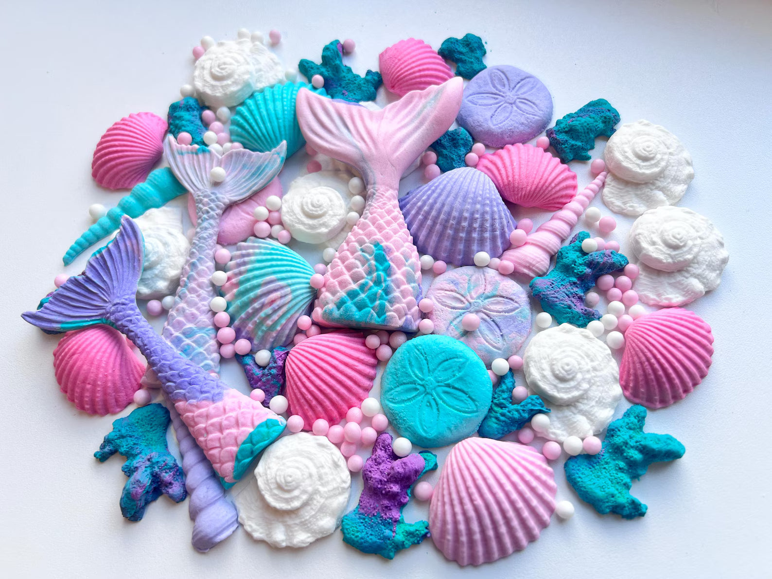 Large edible under the sea cake decorations featuring mermaid tails, shells, starfish and coral in pastel colors