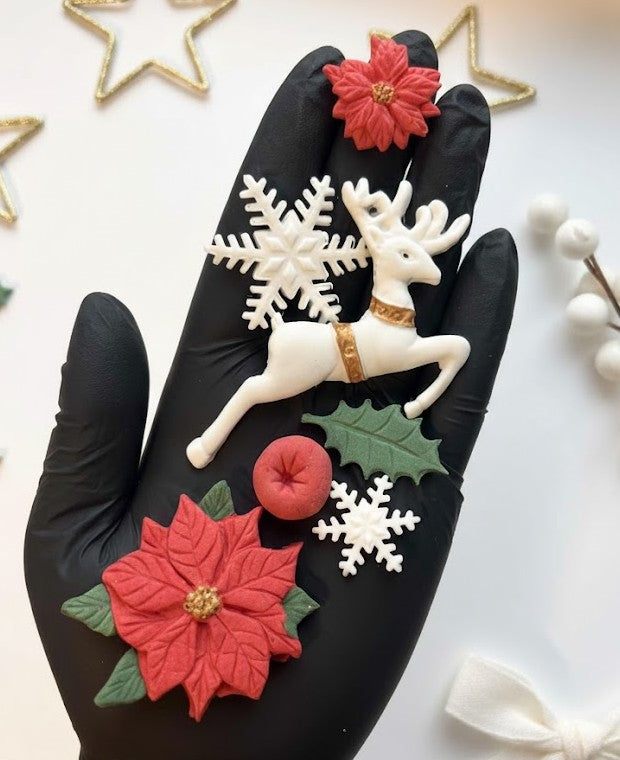 Close up of edible fondant poinsettias holly leaves red berries and white snowflakes