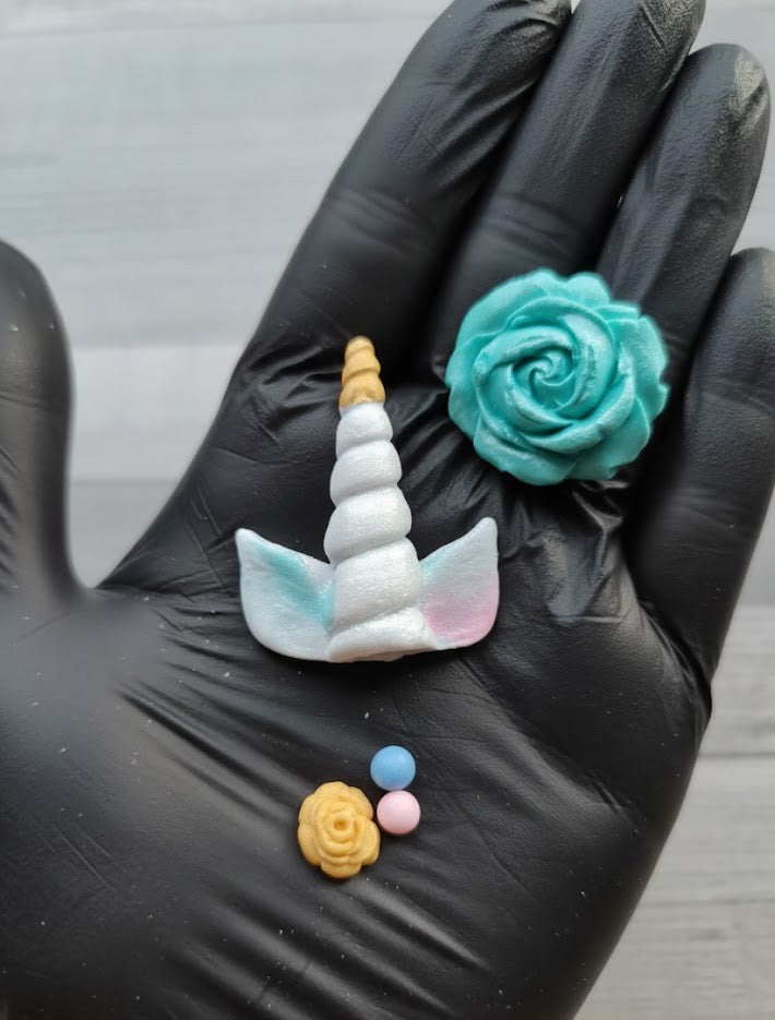 Unicorn themed cake toppers with fondant roses and decorative sugar balls